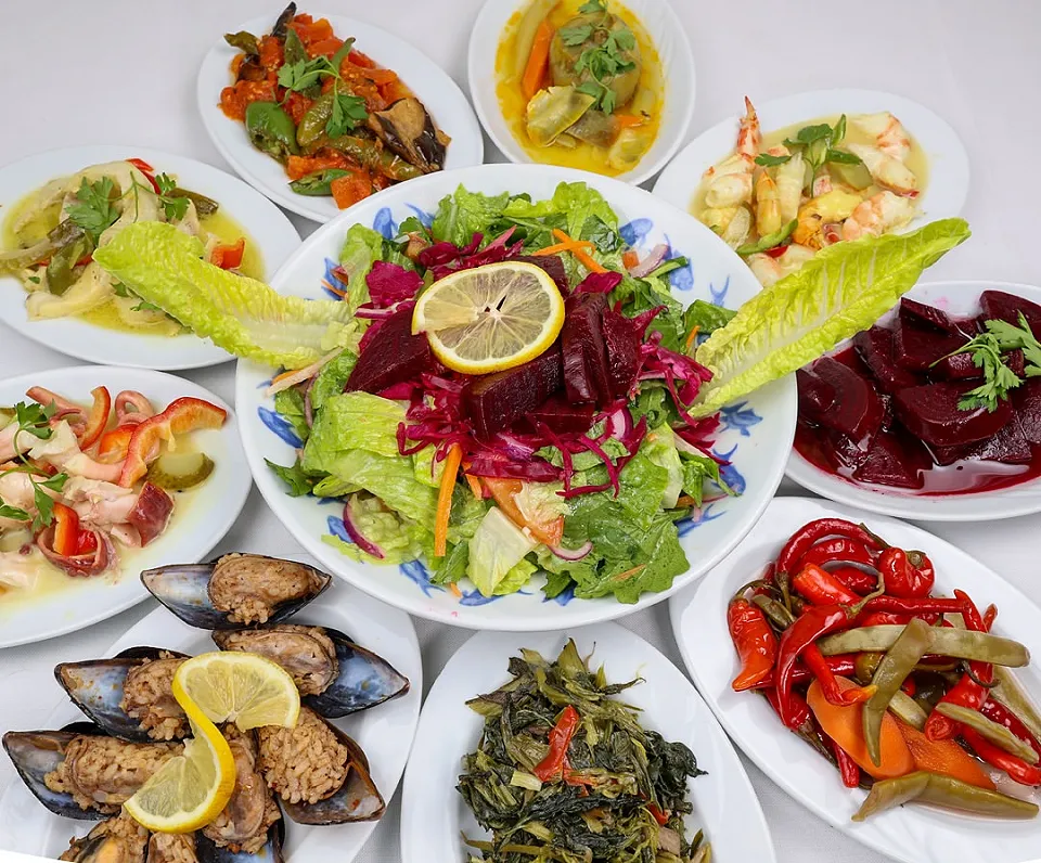 Midye dolma, pancar, közlenmiş biber, zeytinyağlı otlar ve ortada renkli salatayla meze sofrası
