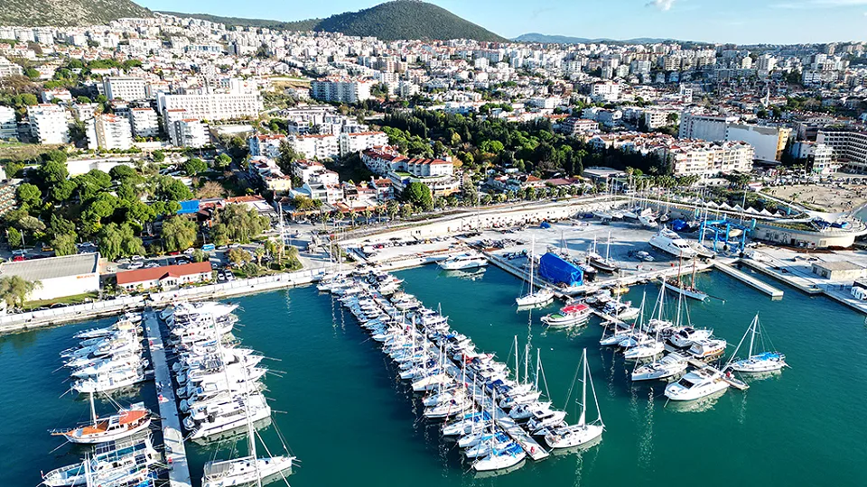 Kuşadası marinası ve iskelelere bağlı yelkenliler, arkada yamaçlara yayılan şehir